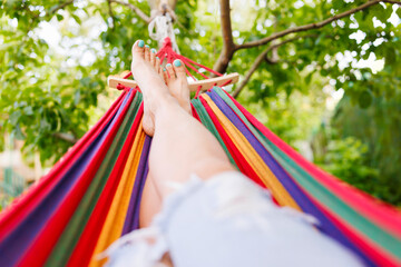 Woman relaxing in a hammock in a summer garden