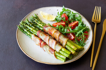 Asparagus baked with bacon and arugula and tomato salad. Healthy eating. Diet.