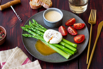 Asparagus with poached egg, tomatoes and hollandaise sause . Healthy eating. Vegetarian food.