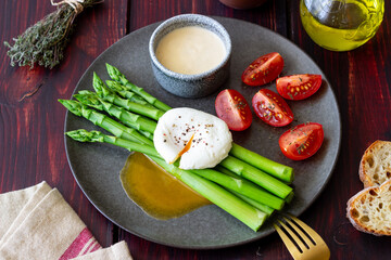 Asparagus with poached egg, tomatoes and hollandaise sause . Healthy eating. Vegetarian food.
