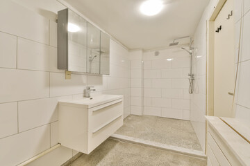 Fototapeta na wymiar a bathroom with white tile walls and flooring the shower area is separated by two large mirrors on the wall