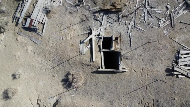 Camera lowers over the opening of an abandoned mine shaft