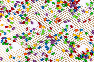 Candy coated sunflower seeds on shiny gold geometric lined paper