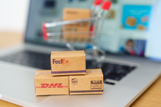 Shipping Boxes on laptop. Popular worldwide shipping and logistic company, Amazon, DHL, FedEx, UPS and OCS express delivery from online shopping. Bangkok, Thailand, 11 June 2023