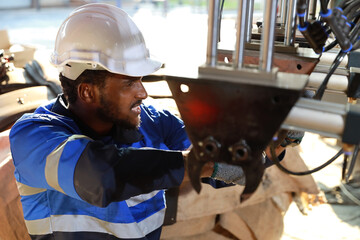 Professional heavy industry technician engineer in safety workwear maintenance and check part of robot arm machine in intelligent factory automotive. Industrial and technology support system concept