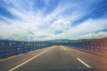 View of the bridge over the river through the windscreen. Beautiful landscape with highway, bridge...