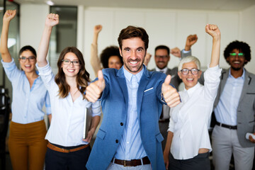 Fototapeta premium Group of successful multiethnic business people celebrating a good job in the office