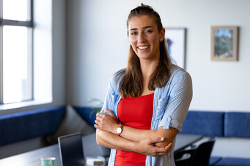 Portrait of happy caucasian casual businesswoman smiling in office