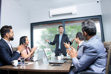 Indian businesspeople clapping and appreciating businessman at conference. Company is greeting partner for sucess in business work.