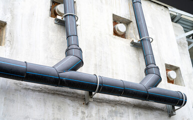 Polyethylene pipes drain water from sky train tracks. HDPE pipeline drainage. Black PE tube was...