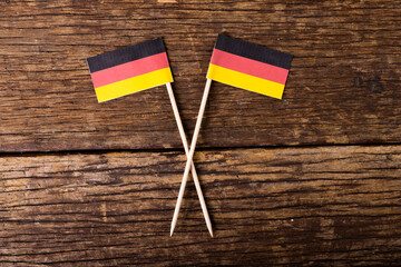 Overhead view of small german flags on wooden table, copy space