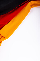 Overhead view of german national flag over white background, copy space