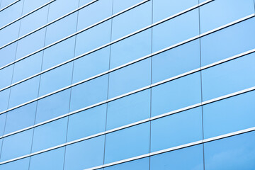Part of a modern glass building, an aluminum facade that reflects the blue sky.