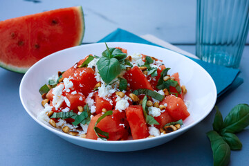Summer salad with watermelon and feta cheese on a garden table