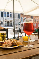 SPRITZ APERITIF IN VENICE ITALY WITH A HISTORICAL PALACE BACKGROUND