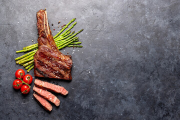Medium rare grilled Tomahawk beef steak with asparagus