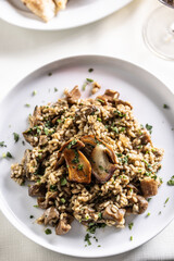 Top view of a speltotto or risotto with two big mushrooms on top