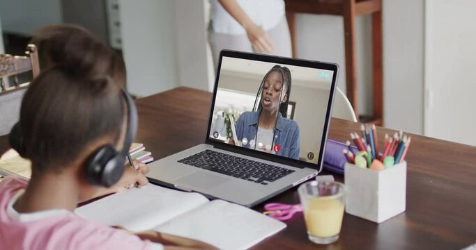 African american girl using laptop for video call with african american female student on screen