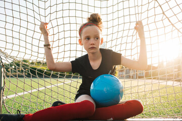 girl sat in a football goal waiting for her match to start