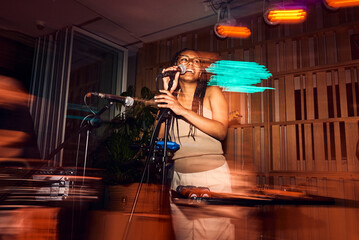 Beautiful black girl talking into microphone during live jazz show