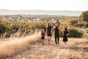 happy family Three daughters dad mom walk in the countryside in nature
