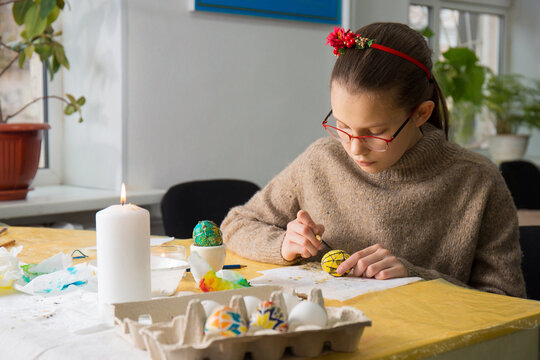 A girl paints Easter eggs in Ukrainian method