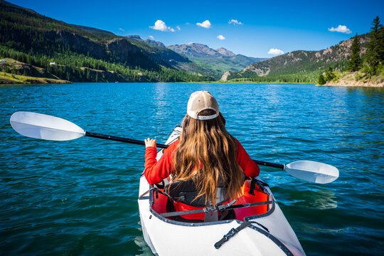 Woman Kayaking the blue waters of Lake San Cristobal