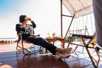 beautiful woman relaxing on wooden deck above Chiang Rai
