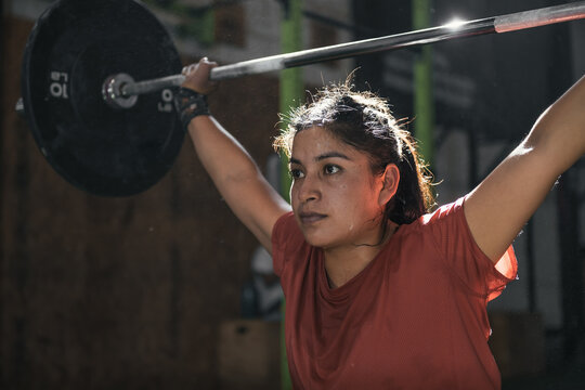 Latin woman with dumbbells in the gym doing crossfit. Per&uacute;.