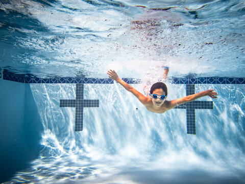 Underwater photograph of boy diving into water.