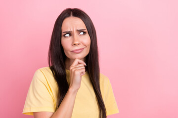 Photo of doubtful suspicious lady wear yellow t-shirt arm chin looking empty space isolated pink color background
