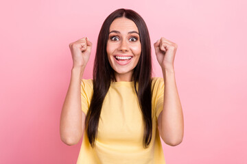 Obraz na płótnie Canvas Photo of excited funny lady raise arms fists celebrate achievement news delighted wear yellow shirt isolated pink color background
