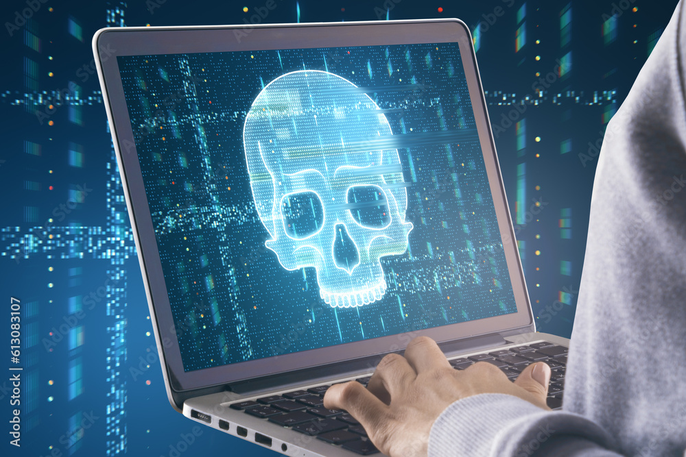 Poster close up of hands using laptop with glowing digital blue glitch skull on screen. blurry background. 
