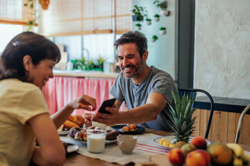Husband and wife having fun breakfast at home