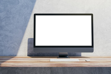 Close up of blank mock up computer screen on wooden desktop and concrete wall background with shadow. Designer desktop and ad concept. 3D Rendering.