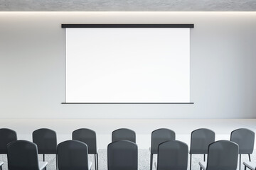Front view on blank white poster with space for advertising text or logo on light wall background opposite black chair rows in lecture hall, seminar or marketing concept. 3D rendering, mock up