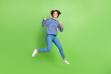 Fototapeta na wymiar Full length photo of youngster woman jumping shopaholic thumbs up recommend new active vacation advert isolated on green color background