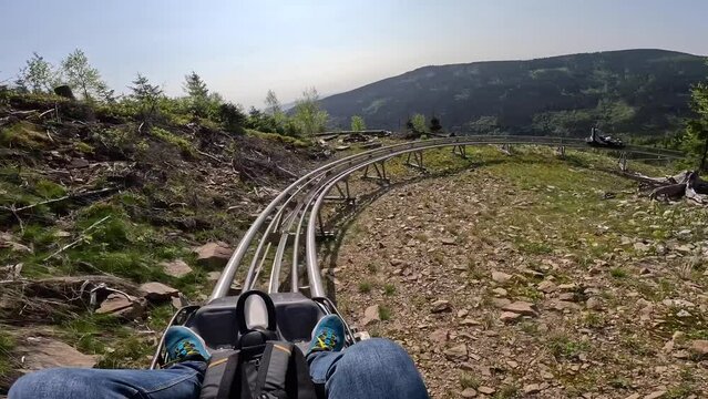 Revelstoke Roller Coaster in mountains with forest. male rides on the Revelstoke, summer attraction in mountain ride. Entertainment and recreation concept