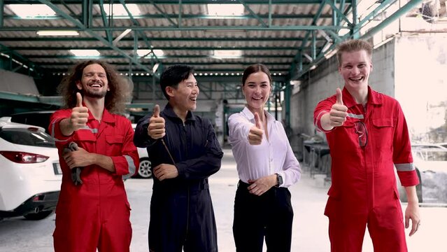 Group of happy technician team thumbs up smiling to camera, professional young multi-ethnic people joint venture together open repair garage, several capability technicians join business start-up