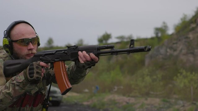 Portrait of Ukrainian soldier shooting at the range