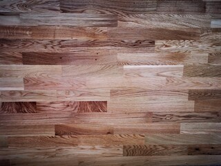 The background for a natural oak parquet board of three strips