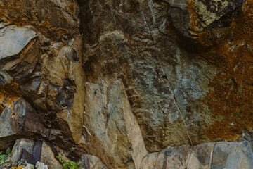 Texture of mossy mountain rock, rocky surface with ancient moss