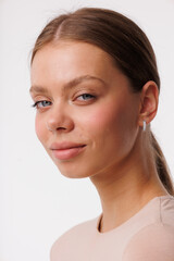 Beautiful young girl with fresh  healthy skin. Woman advertise ear-rings. White background. Earrings closeup. Blond european woman with long hair with big lips, pretty smile. Cosmetology,  scincare