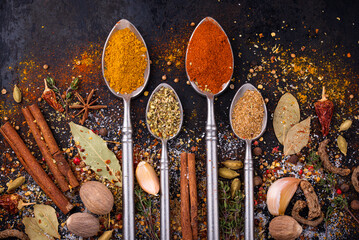 Fototapeta na wymiar Different spices and herbs on a black background