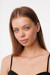 Naklejka premium Beautiful young girl with fresh healthy skin. Woman advertise ear-rings. White background. Earrings closeup. Blond european woman with long hair with big lips, pretty smile. Cosmetology, scincare