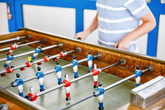 Close-up Of Kid Boy Playing Table Soccer. Happy Excited Child Having Fun With Family Game With Siblings Or Friends. Positive Kid.