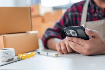 Entrepreneurs Small Business SME Independent men work at home Use smartphones and laptops for commercial checking, online marketing, packing boxes, SME sellers, concept, e-commerce team, online sales
