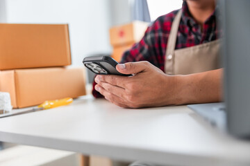 Fototapeta premium Entrepreneurs Small Business SME Independent men work at home Use smartphones and laptops for commercial checking, online marketing, packing boxes, SME sellers, concept, e-commerce team, online sales