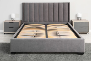 Comfortable bed with storage space for bedding under slatted base in room - obrazy, fototapety, plakaty
