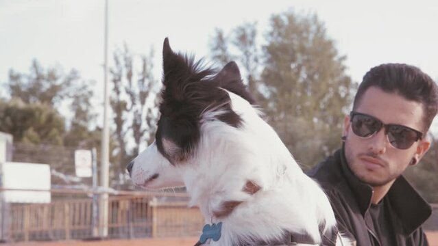 Video of a young man walking with his border collie in an outdoor park. Videos of Border Collie dogs.